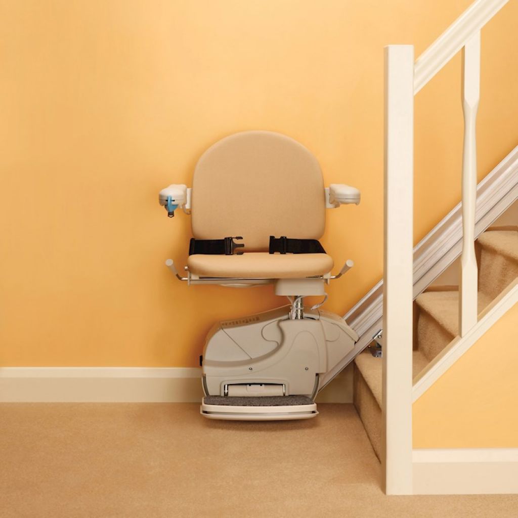 A reconditioned stairlift installed against a wall on a straight staircase.