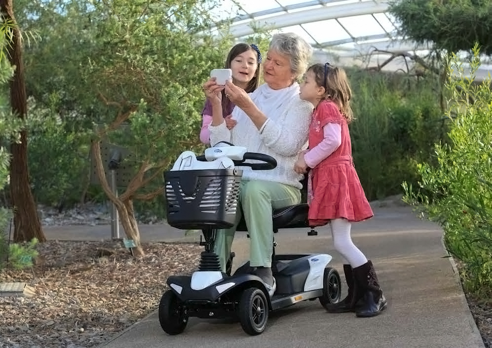 Grandmother on her disability scooter with grandkids beside her
